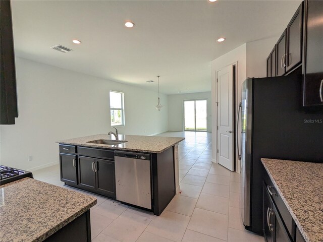 kitchen with appliances with stainless steel finishes, a kitchen island with sink, a healthy amount of sunlight, and sink