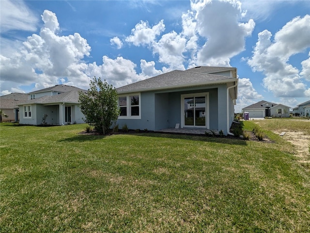 rear view of property featuring a yard and a garage