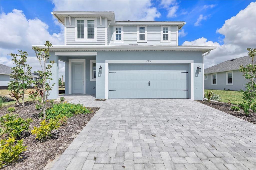 15876 Mulrion Blvd, Punta Gorda, FL 33982 - traditional-style house featuring an attached garage, stucco siding, and decorative driveway
