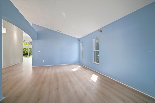 unfurnished room with light hardwood / wood-style floors and vaulted ceiling