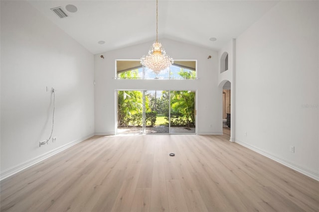 interior space featuring an inviting chandelier, high vaulted ceiling, and light hardwood / wood-style flooring