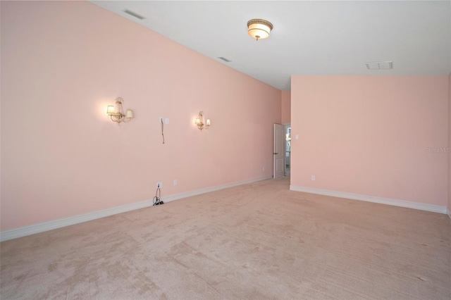 carpeted spare room featuring lofted ceiling