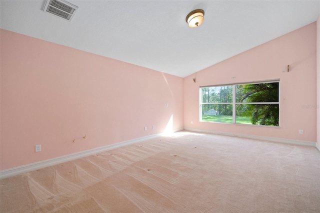 carpeted empty room featuring lofted ceiling