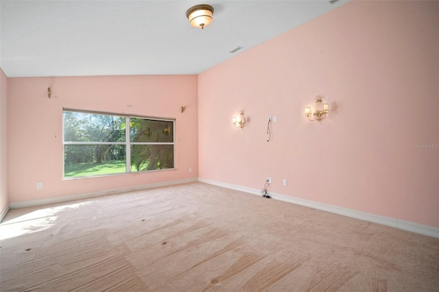 empty room with light colored carpet and lofted ceiling