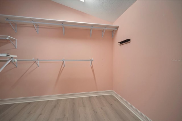 spacious closet with wood-type flooring and lofted ceiling