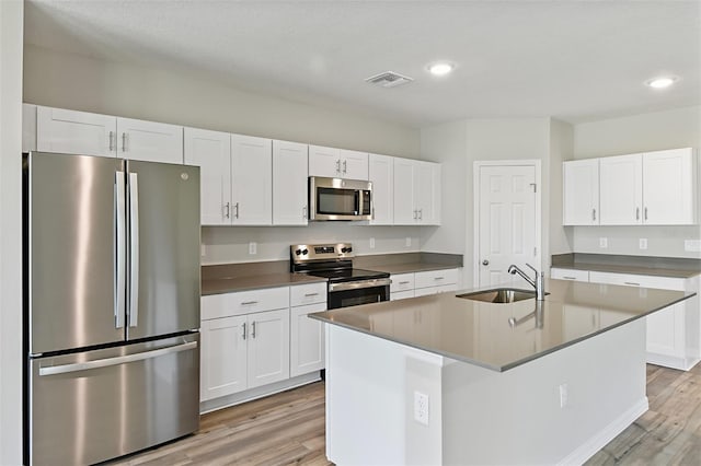 kitchen featuring appliances with stainless steel finishes, light hardwood / wood-style flooring, white cabinets, and sink