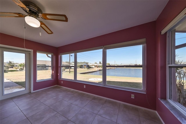 unfurnished sunroom with a water view, a wealth of natural light, and ceiling fan