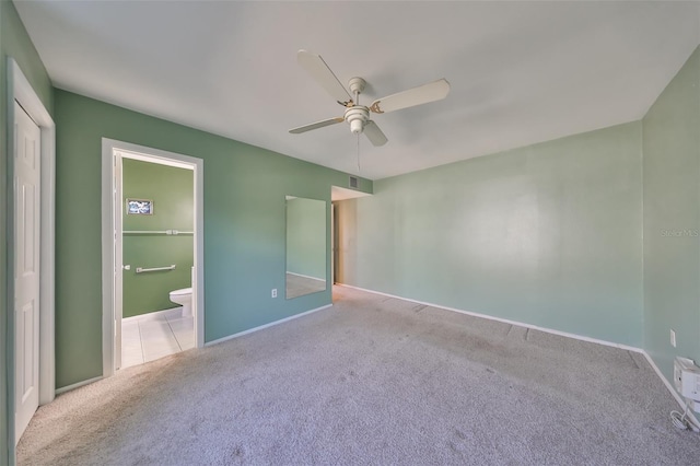 unfurnished bedroom featuring light carpet, ensuite bathroom, and ceiling fan