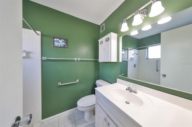 bathroom featuring tile patterned floors, toilet, vanity, and tiled shower