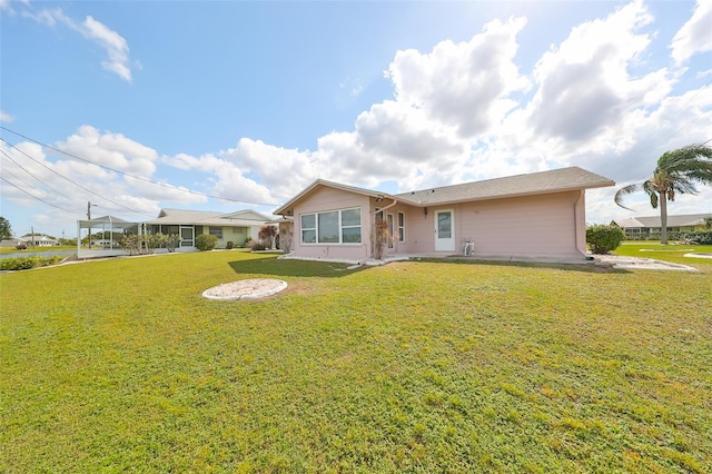 rear view of property with a yard