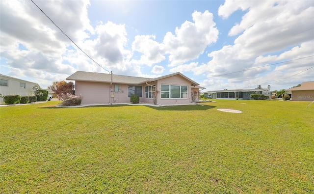 rear view of property with a lawn