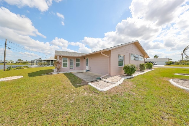 rear view of property featuring a lawn and a patio