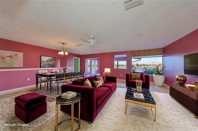 living room featuring ceiling fan with notable chandelier and lofted ceiling