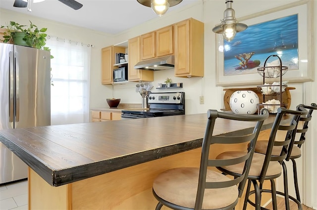 kitchen featuring a kitchen bar, light brown cabinets, kitchen peninsula, and stainless steel appliances