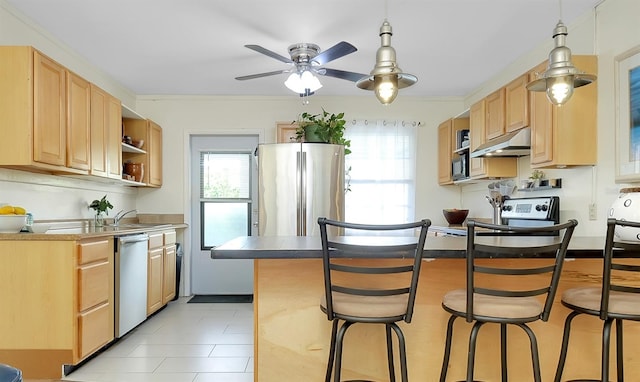 kitchen with light brown cabinetry, a kitchen breakfast bar, and appliances with stainless steel finishes