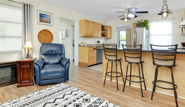 kitchen featuring ceiling fan, light brown cabinetry, light wood-type flooring, and stainless steel fridge