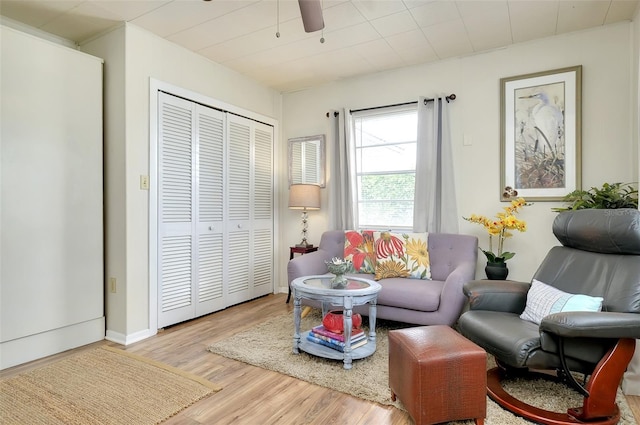 living area with ceiling fan and light wood-type flooring