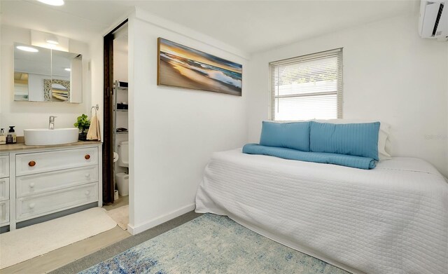 bedroom featuring a wall mounted AC and sink