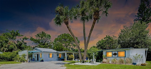 view of front of home featuring a lawn and a carport