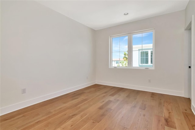 unfurnished room with baseboards and light wood-style flooring