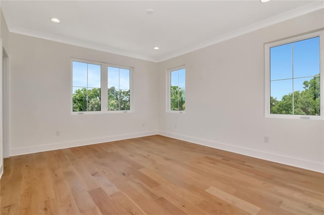 unfurnished room featuring baseboards, ornamental molding, and light wood finished floors