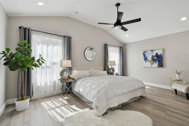 bedroom featuring ceiling fan, lofted ceiling, light hardwood / wood-style floors, and multiple windows