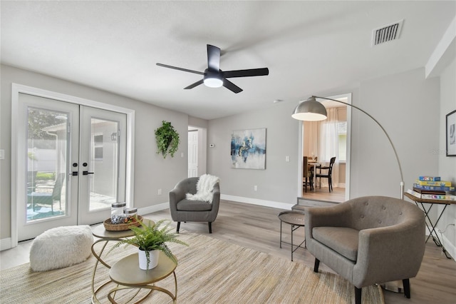 living room featuring french doors, ceiling fan, and a healthy amount of sunlight