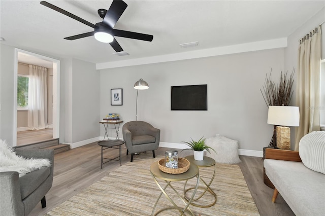 living room with ceiling fan and light hardwood / wood-style floors