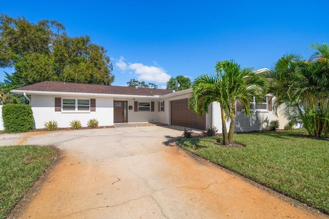 single story home featuring a front lawn and a garage