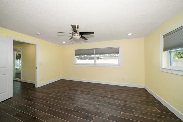 empty room featuring a textured ceiling, ceiling fan, and dark hardwood / wood-style flooring