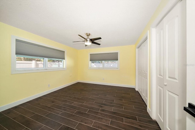 empty room with ceiling fan and dark hardwood / wood-style flooring