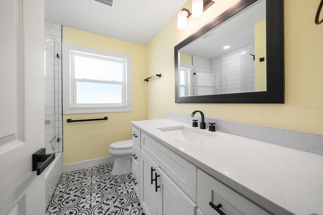 full bathroom featuring toilet, tiled shower / bath combo, vanity, and tile patterned flooring