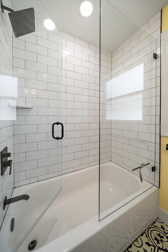 bathroom featuring bath / shower combo with glass door and tile patterned floors