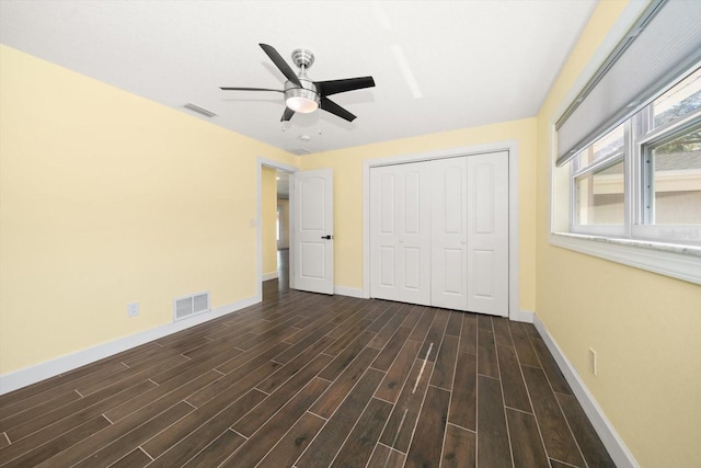 unfurnished bedroom featuring dark wood-type flooring, ceiling fan, and a closet