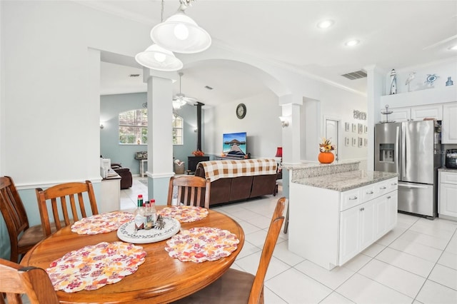 dining space with crown molding, ornate columns, light tile patterned floors, and ceiling fan