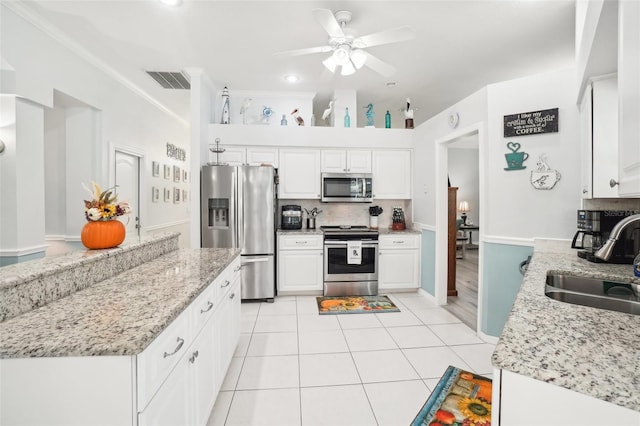 kitchen featuring light stone countertops, sink, appliances with stainless steel finishes, and white cabinets