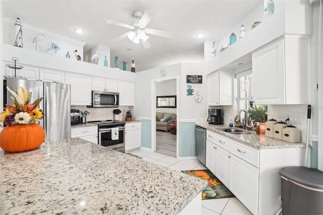 kitchen with sink, white cabinets, stainless steel appliances, and ceiling fan