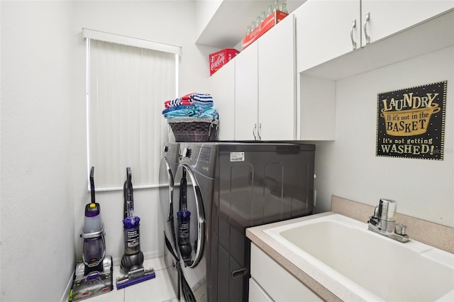 clothes washing area with cabinets, light tile patterned flooring, sink, and washing machine and dryer