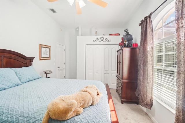 carpeted bedroom with a closet, ceiling fan, and lofted ceiling