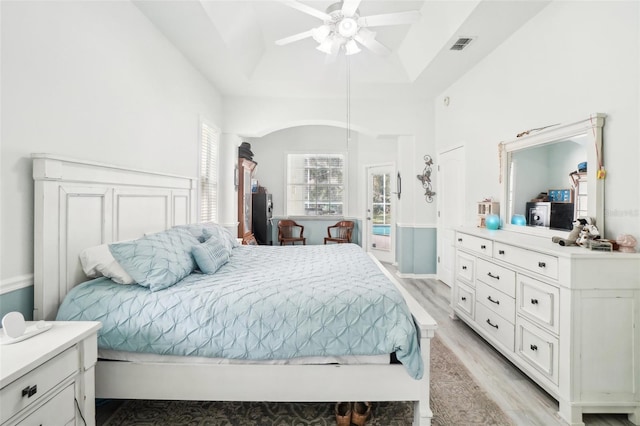 bedroom featuring light hardwood / wood-style flooring, a raised ceiling, and ceiling fan