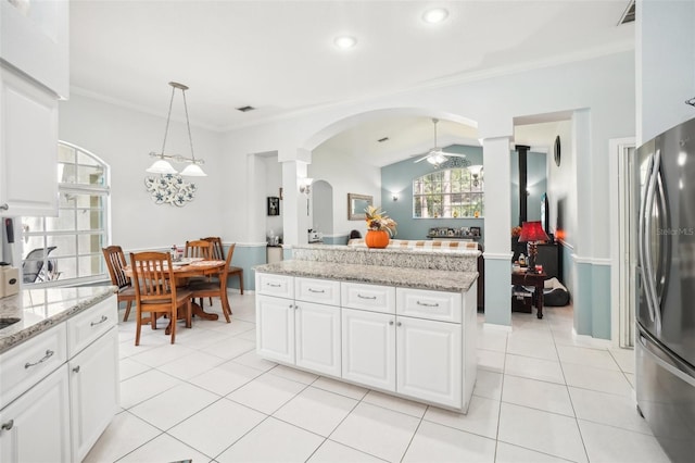 kitchen featuring crown molding, white cabinetry, hanging light fixtures, and stainless steel refrigerator