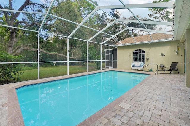 view of swimming pool featuring a patio area and glass enclosure