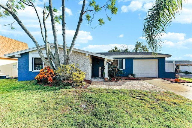 view of front of home with a garage, concrete driveway, a front lawn, and stucco siding