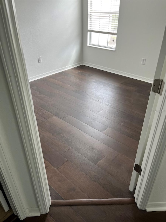 unfurnished room with dark hardwood / wood-style flooring