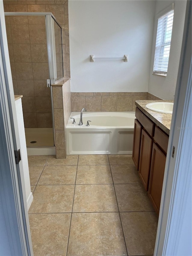 bathroom with shower with separate bathtub, vanity, and tile patterned floors