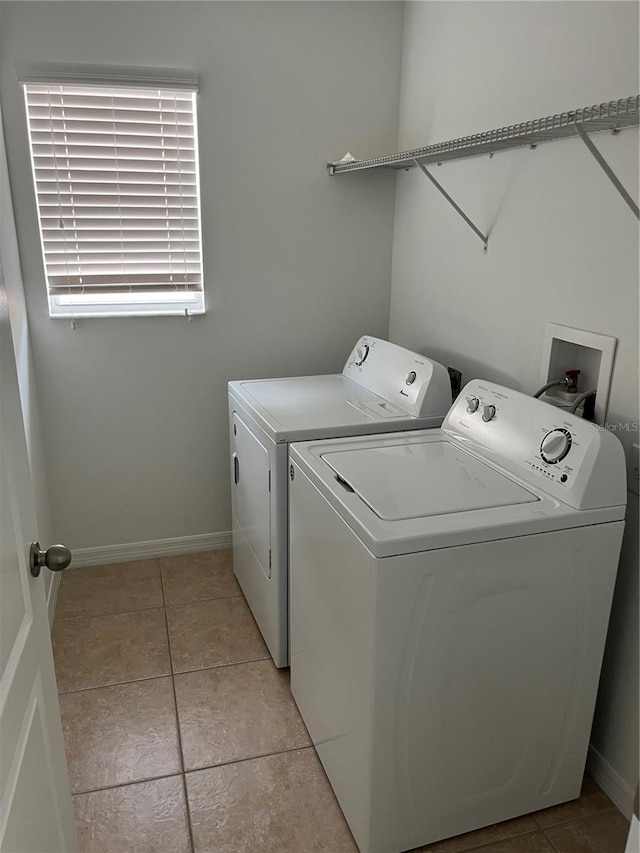 laundry area featuring washing machine and clothes dryer and light tile patterned floors