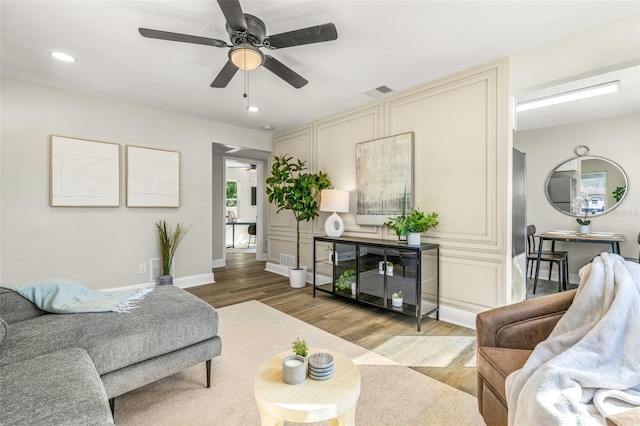 living room featuring ceiling fan and light hardwood / wood-style flooring