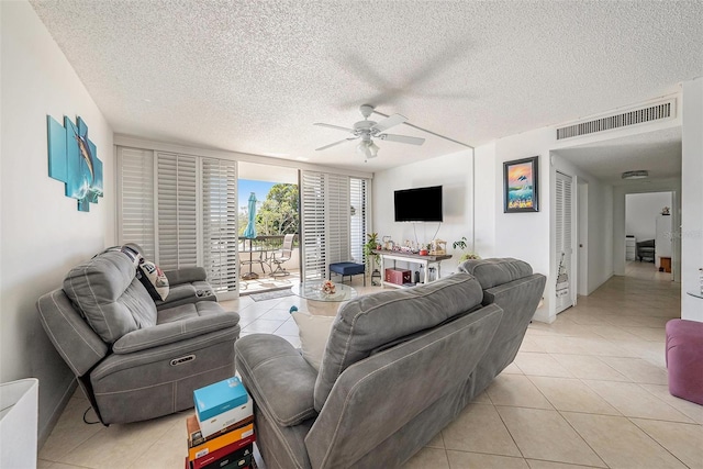 living room featuring light tile patterned flooring, a textured ceiling, and ceiling fan