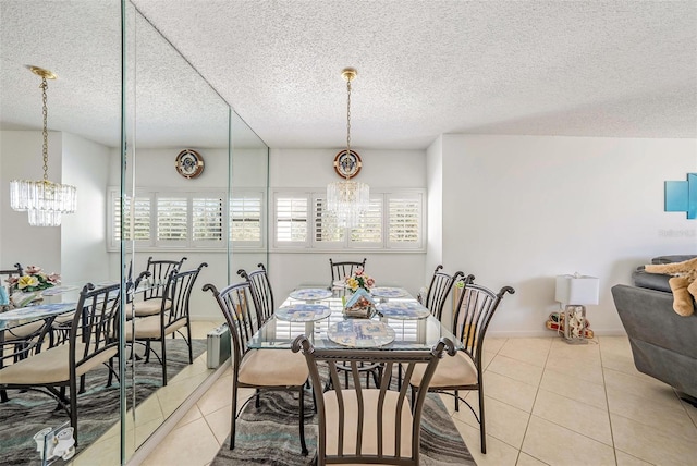 dining area with a textured ceiling, light tile patterned flooring, and a chandelier