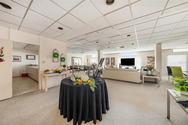 carpeted living room featuring a paneled ceiling